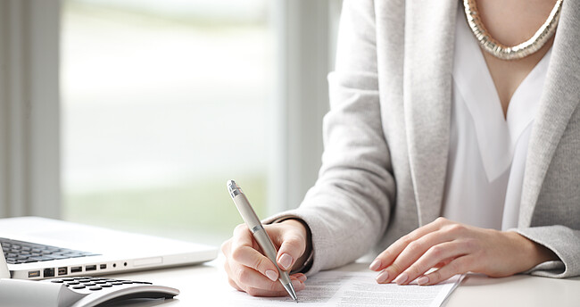 Frau füllt ein Formular aus Frau füllt einen Antrag aus