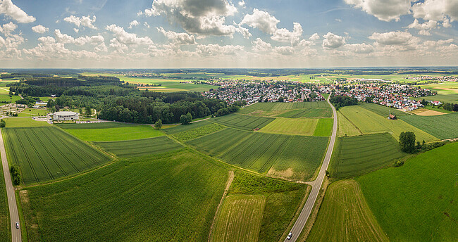 Ländlicher Raum Bild zeigt Landwirtschaft mit Ort im Hintergrund