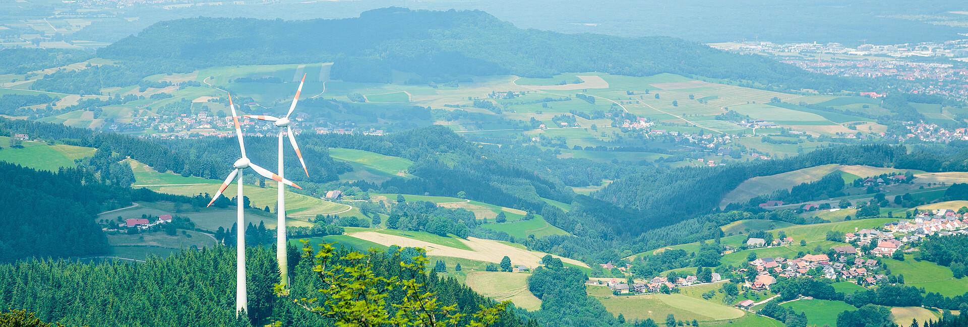 Windenergieanlagen auf dem Schauinsland Man blickt von oben auf zwei Windenergieanlagen, die im Wald auf dem Berg Schauinsland stehen.